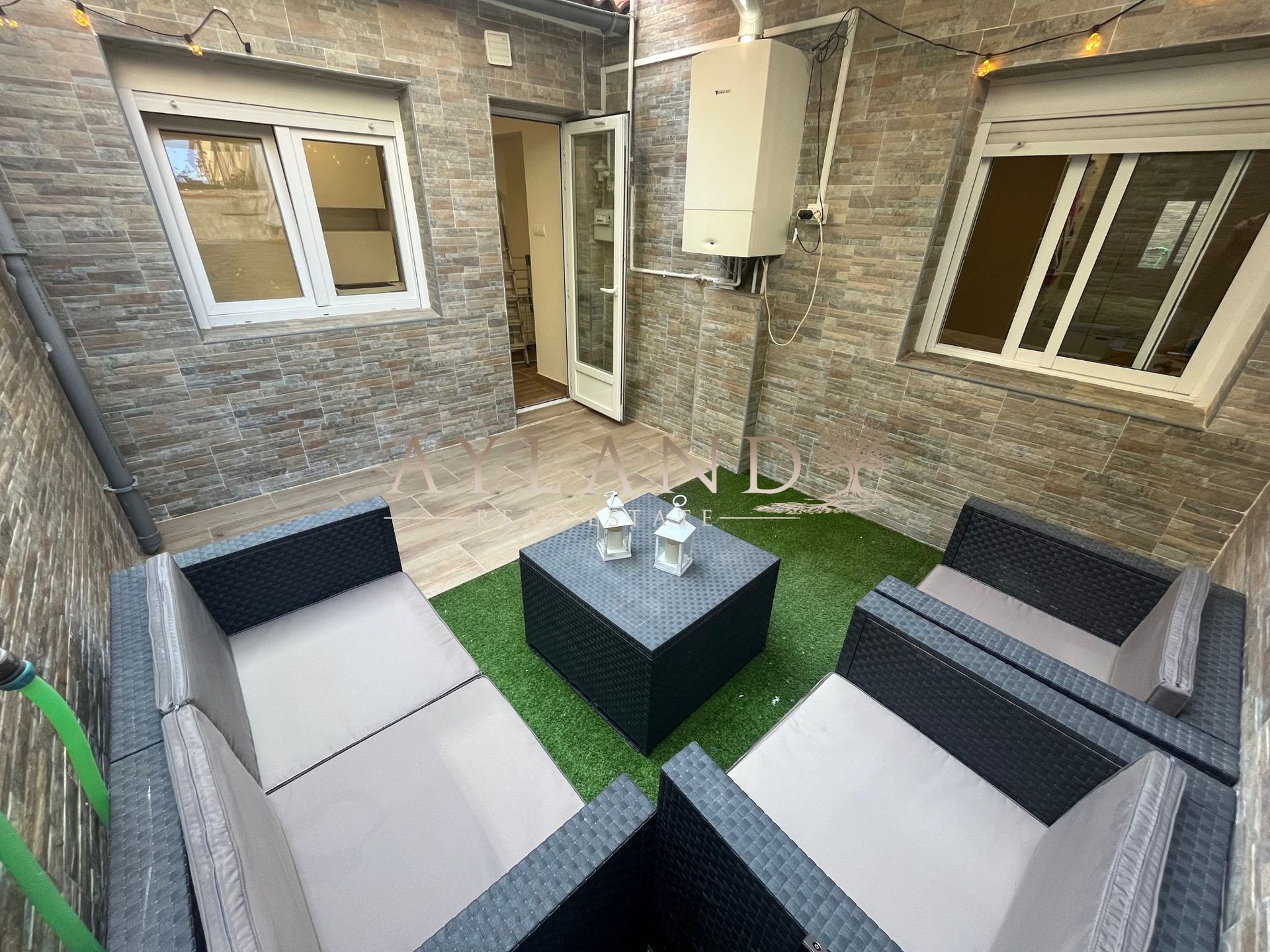 El patio, con césped artificial y muebles de exterior