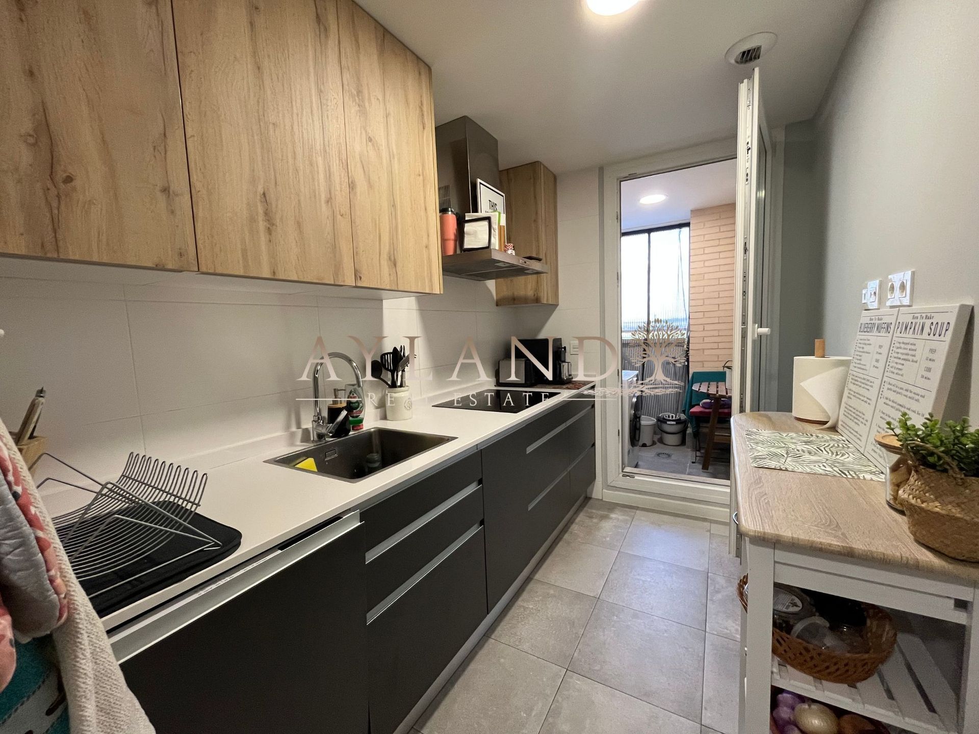La cocina, con los muebles altos y salida a la terraza