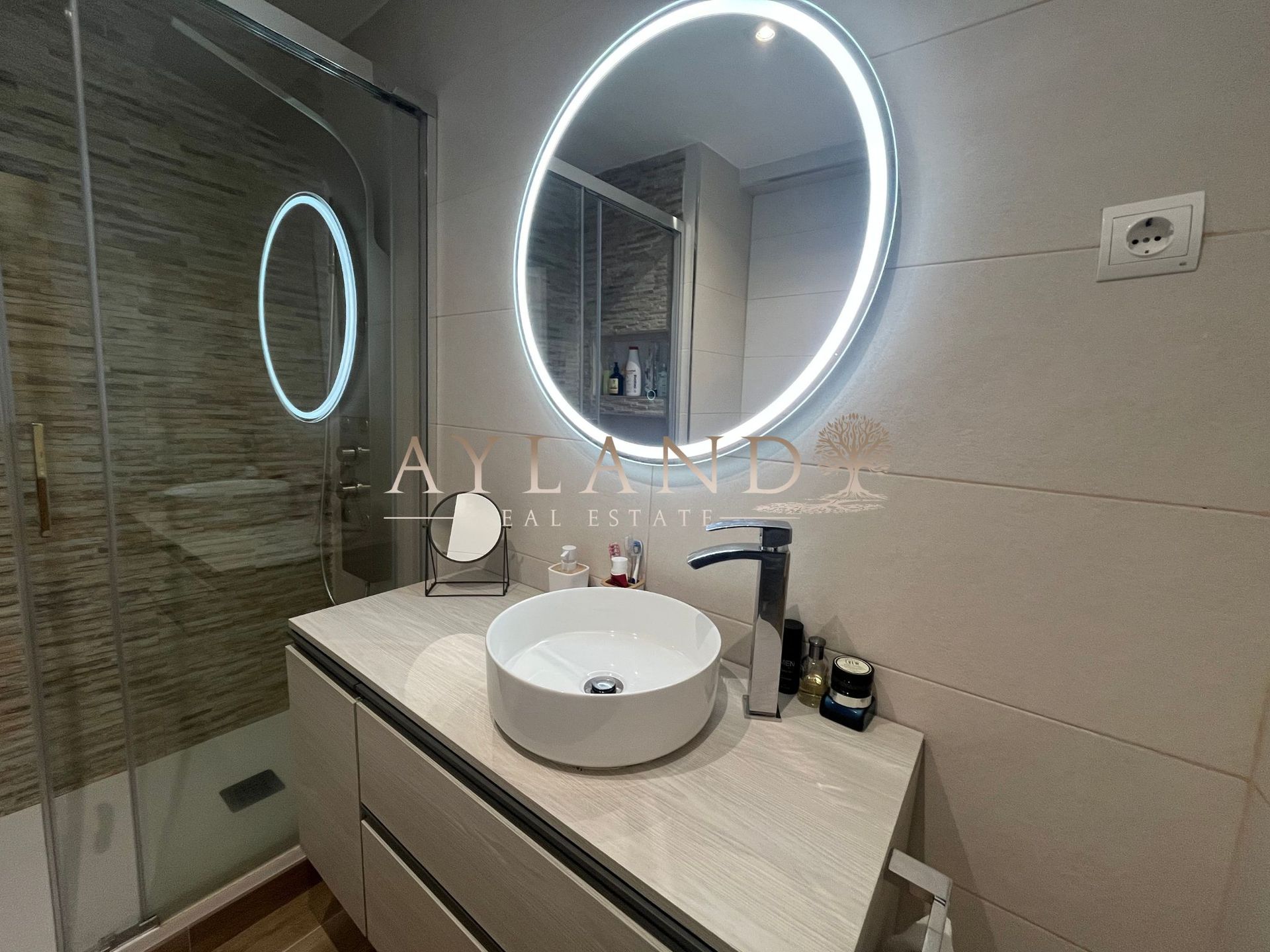 El espejo circular del baño, encendido