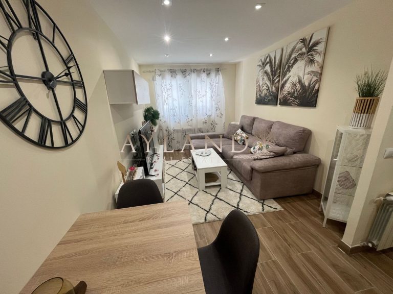 Salón comedor de Salvador, en Getafe, con sofá gris y suelo de tarima clara