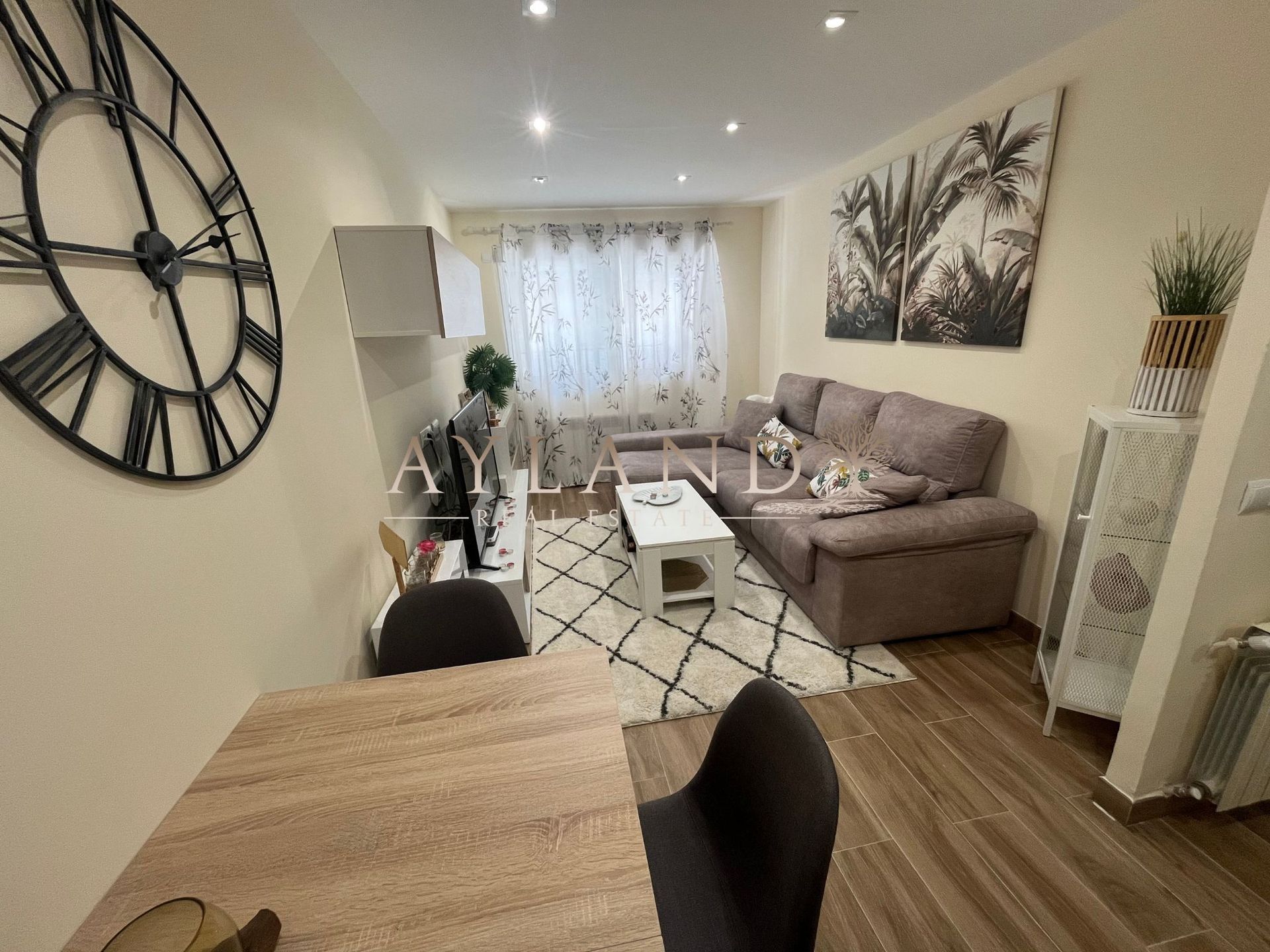 Salón comedor de Salvador, en Getafe, con sofá gris y suelo de tarima clara