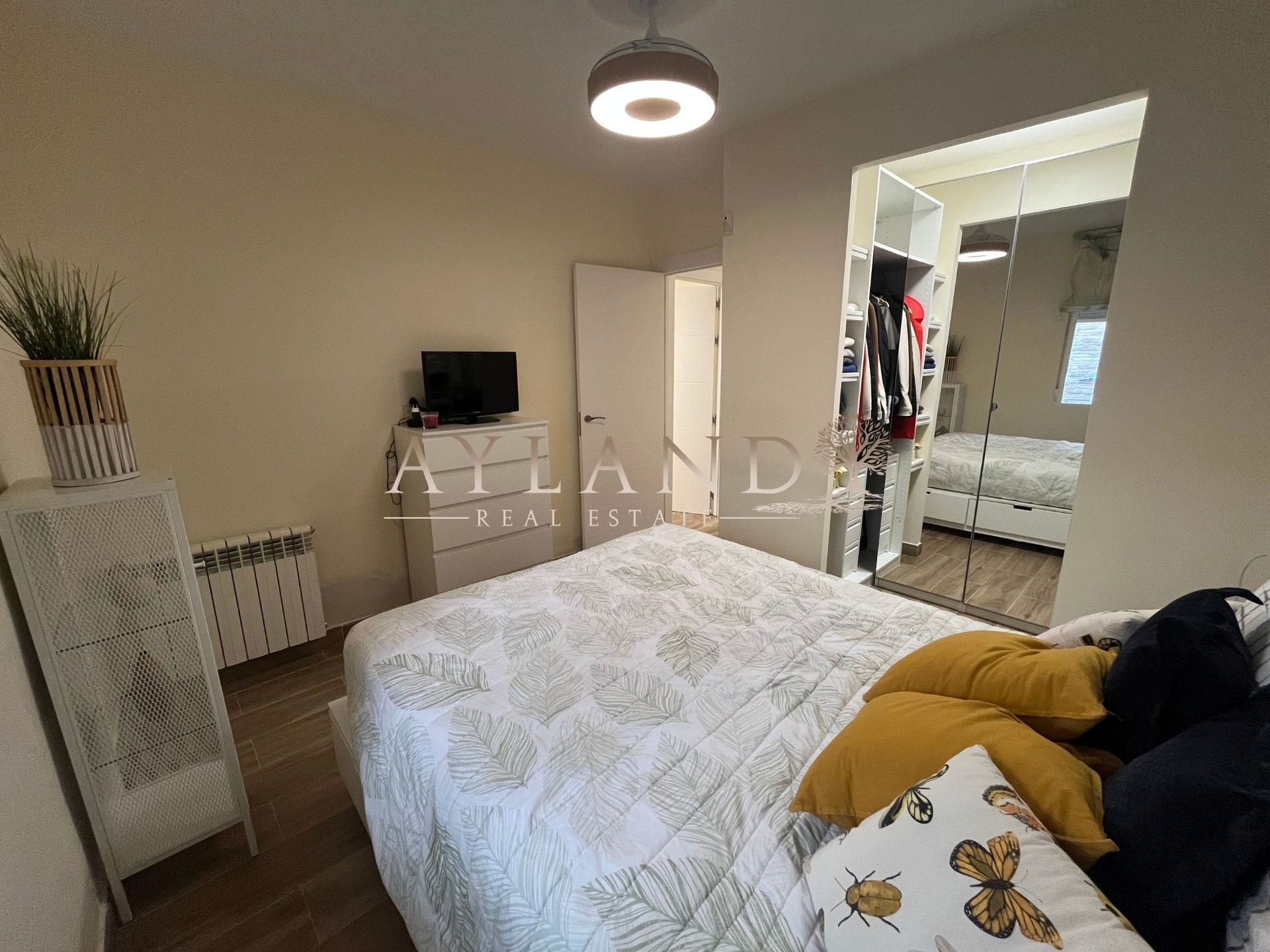 Dormitorio con armario de puertas de espejo
