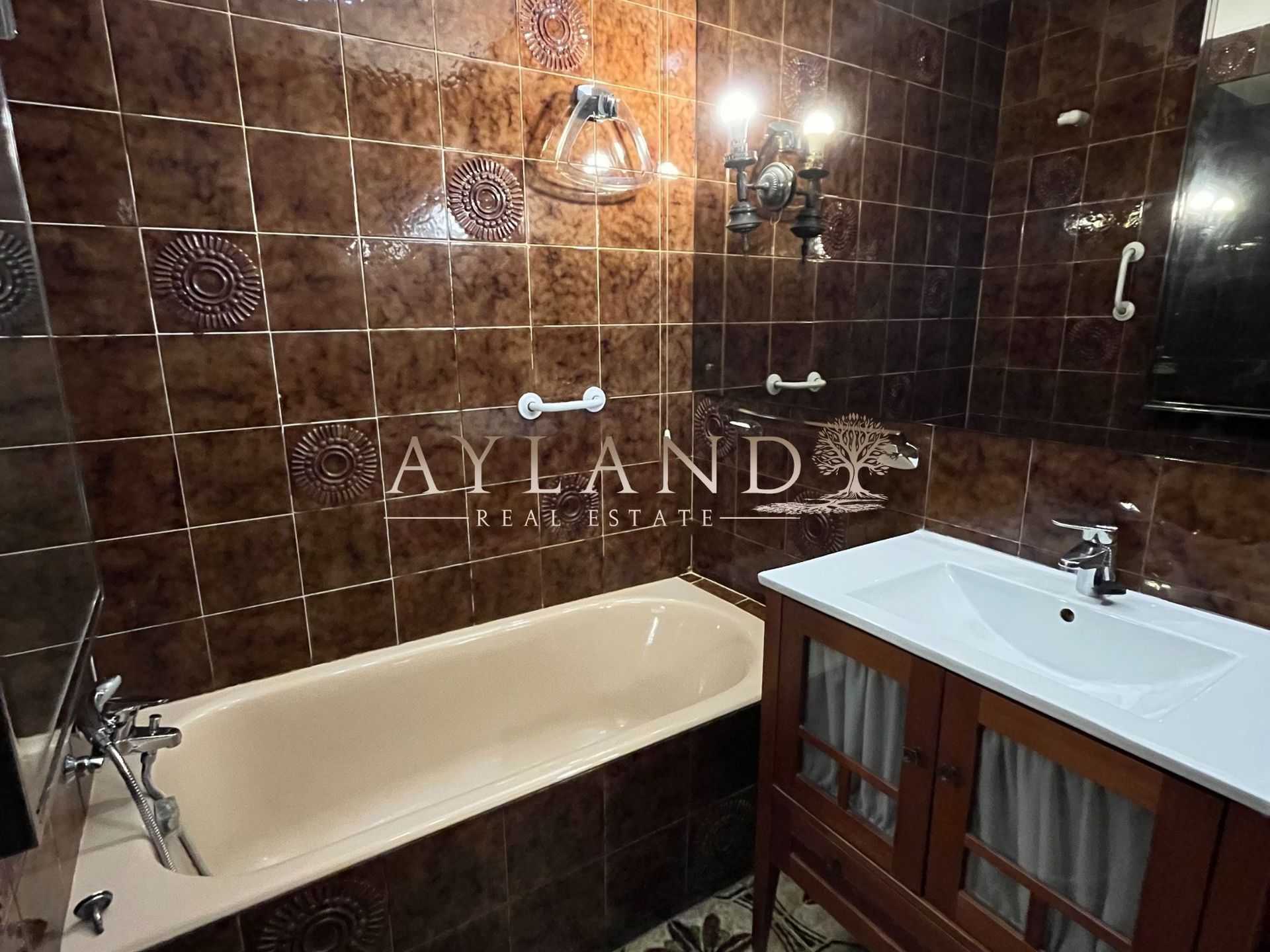 Baño con bañera, alicatado en marrón