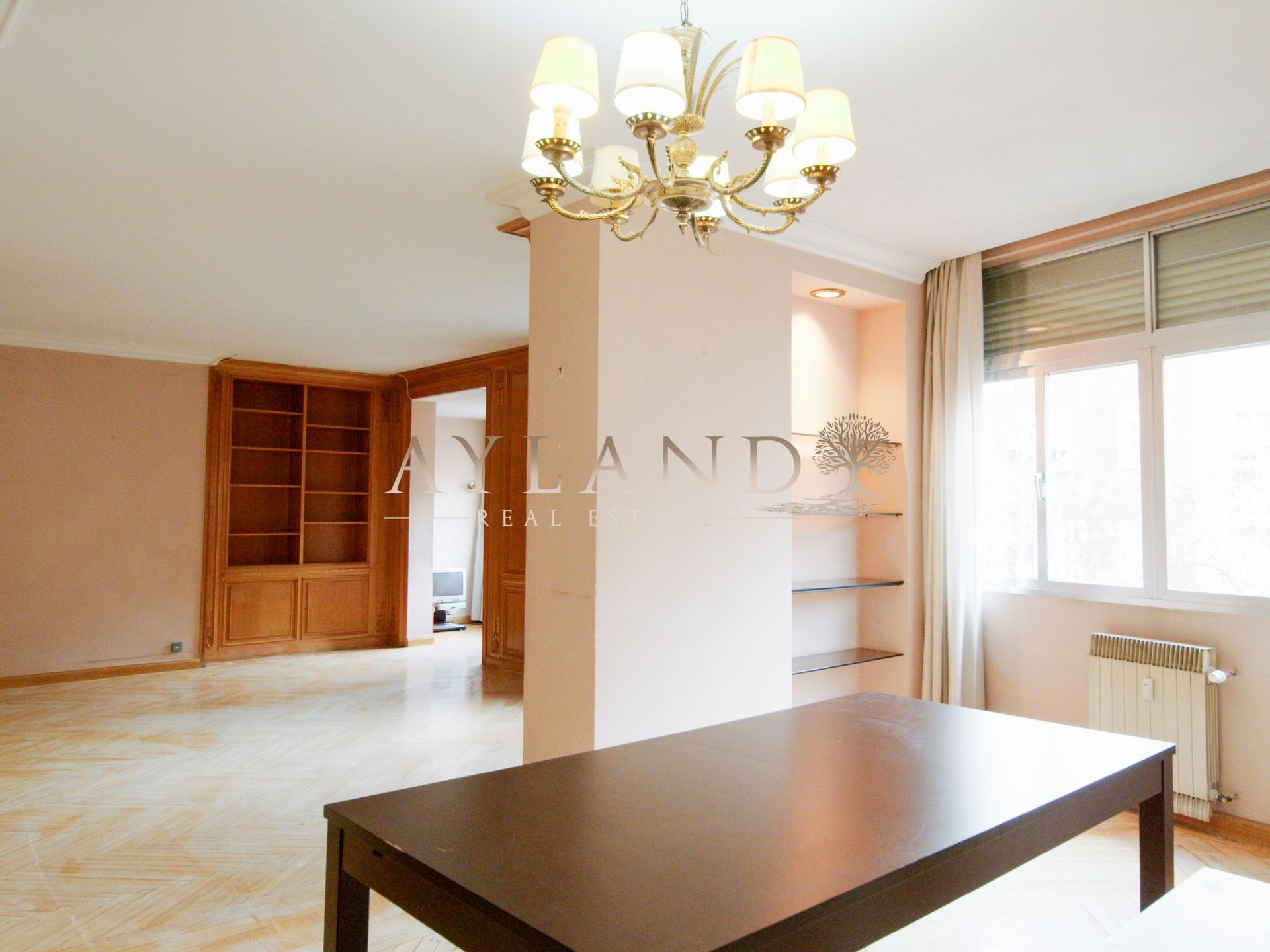 Salón de Fortunata y Jacinta con librería empotrada de madera y mesa de comedor