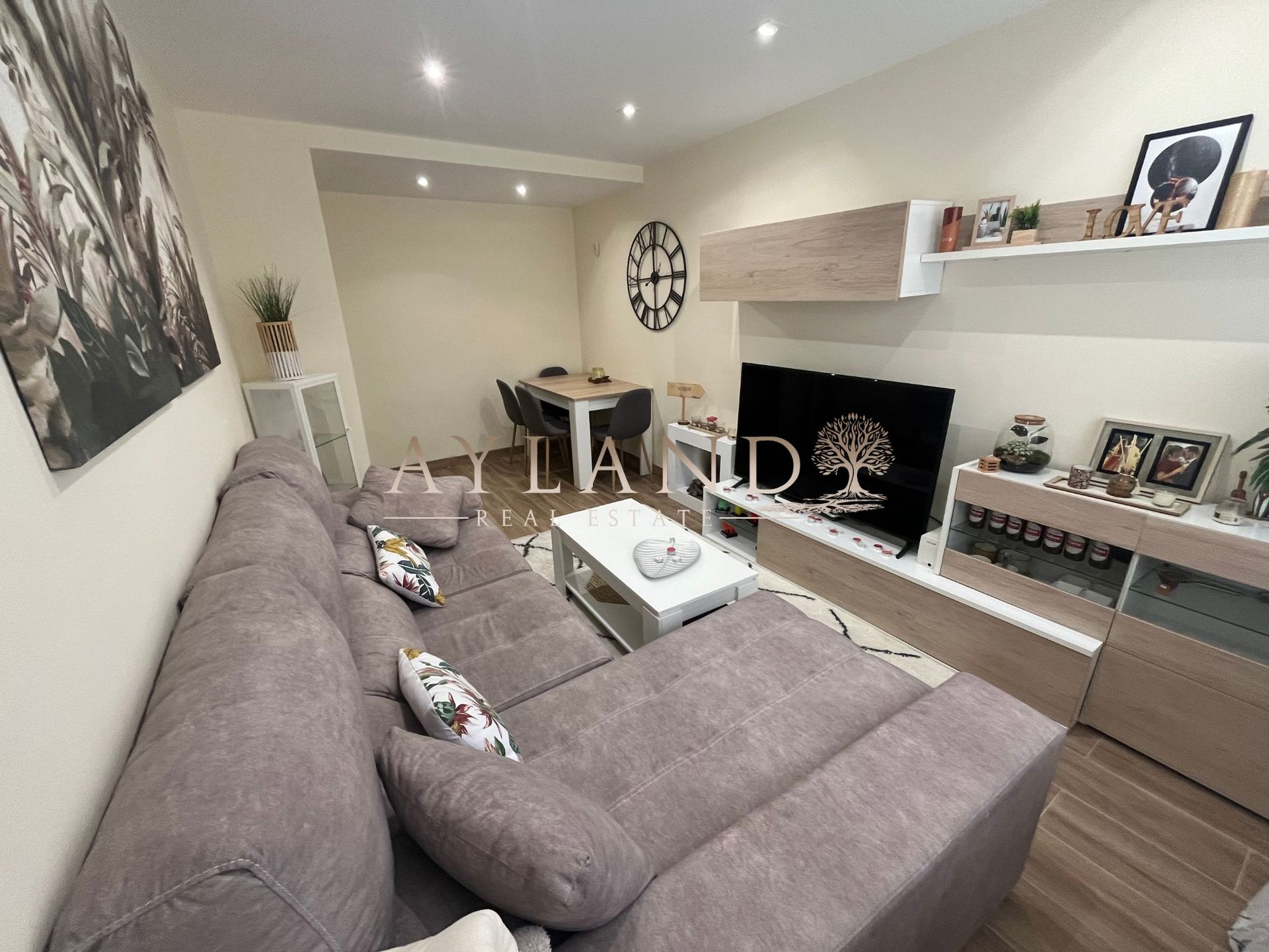 El salón, con el reloj de pared y el comedor al fondo